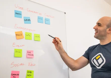 man placing sticky notes on a whiteboard