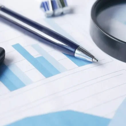 Magnifying glass, calculator, and charts on a desk