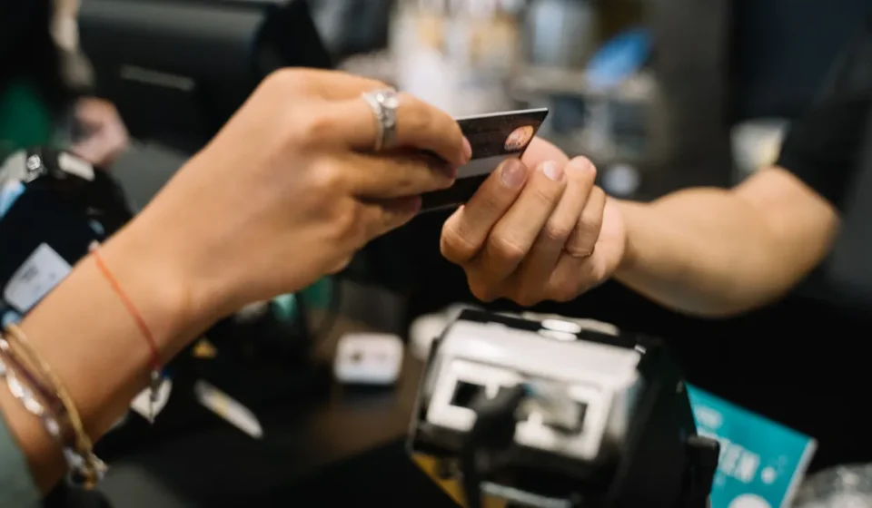hands exchanging a payment card at checkout