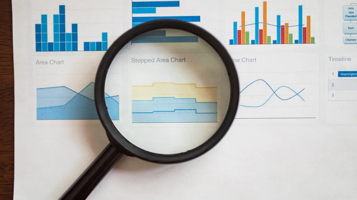 Magnifying glass over printed charts and graphs