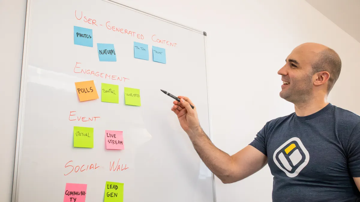 How to Write SEO Articles for Topic Clusters Person pointing at a whiteboard of color-coded sticky notes