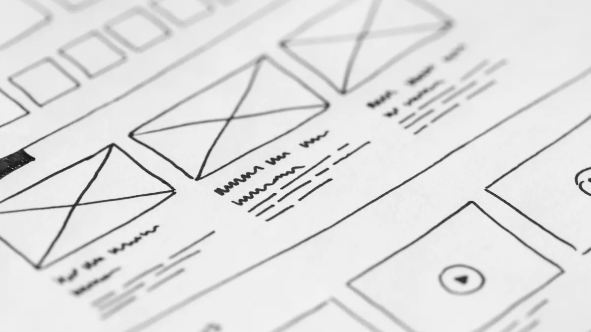 Paper website wireframe sketch with layout boxes and image placeholders